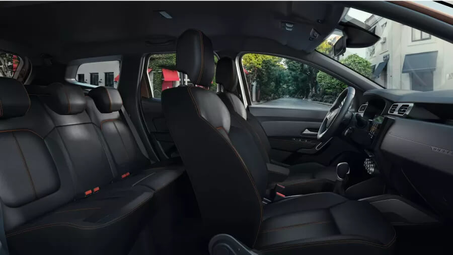 Интерьер Renault Duster с черными сиденьями и просторным задним рядом на фоне городской улицы.