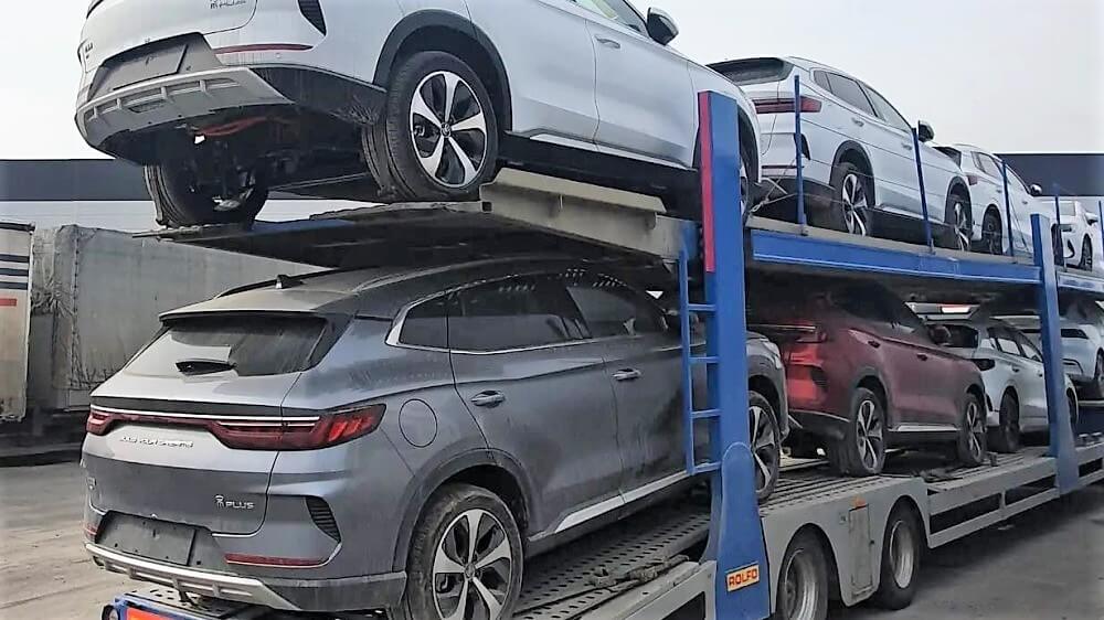 Перевозка перепродаваемых китайских авто на автовозе. Несколько автомобилей размещены в два ряда, подготовлены для доставки.
